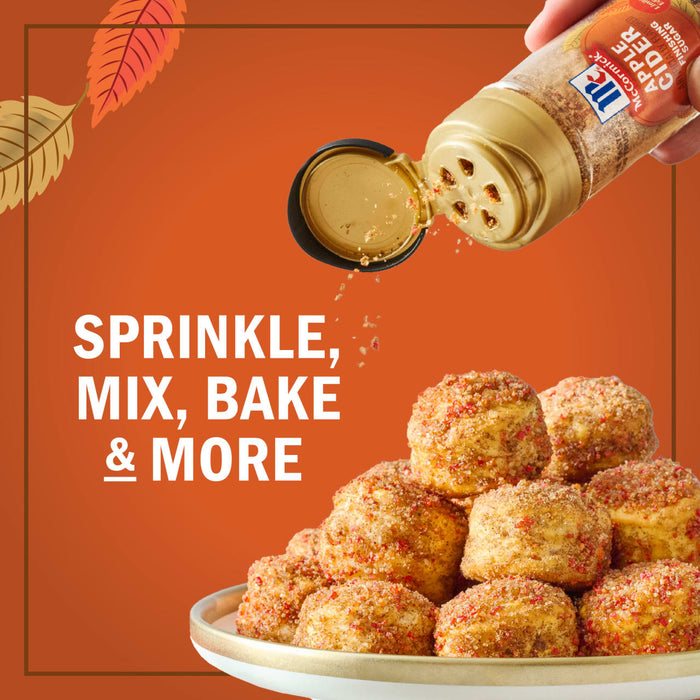 A hand sprinkles McCormick Pumpkin Pie Spice onto a stack of baked goods, highlighting its versatility for sprinkling, mixing, baking, and more.
