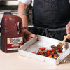 A person is basting grilled vegetables with Frenchs Cattlemens BBQ Sauce.