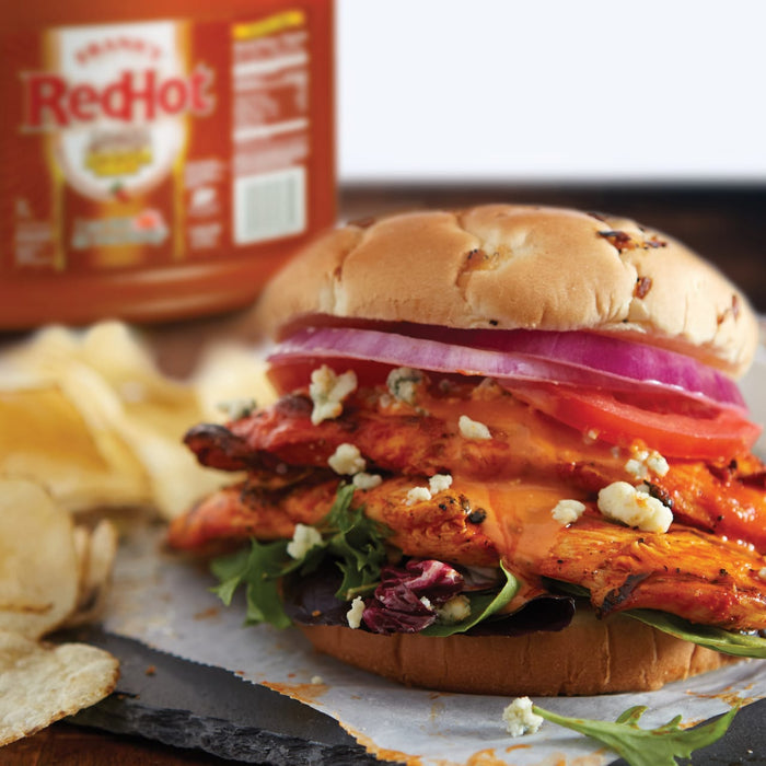 A RedHot Buffalo Chicken sandwich with lettuce tomato red onion and blue cheese crumbles.