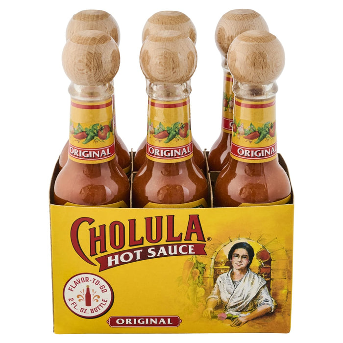 A six-pack of Cholula Original Hot Sauce bottles with wooden tops is displayed in its branded cardboard packaging.