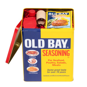 A yellow and red tin of Old Bay Seasoning with a picture of a crab shrimp and chicken on the front.
