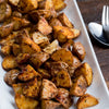 A white plate filled with roasted potato wedges.