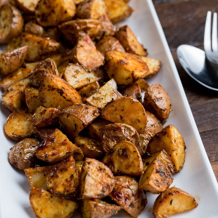 A white plate filled with roasted potato wedges.