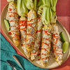 Grilled corn on the cob topped with cotija cheese chili powder and lime wedges.