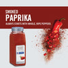 A jar of McCormick Culinary Smoked Paprika with a red pepper falling apart into pieces.