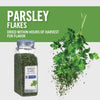 A jar of McCormick Culinary Parsley Flakes with fresh parsley falling from the top.