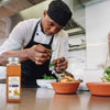 A chef is preparing a dish with McCormick Cajun Seasoning.