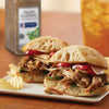 Two Italian-seasoned pulled pork sandwiches on ciabatta rolls with red peppers and provolone cheese.