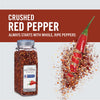 A jar of McCormick Culinary Crushed Red Pepper with a red pepper sliced in half falling into a pile of crushed red pepper.