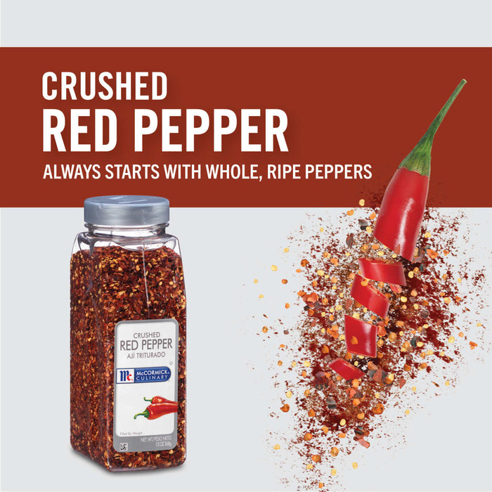 A jar of McCormick Culinary Crushed Red Pepper with a red pepper sliced in half falling into a pile of crushed red pepper.