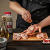 A chef is seasoning Lawrys Lemon Basil &amp; Thyme on quail before cooking.