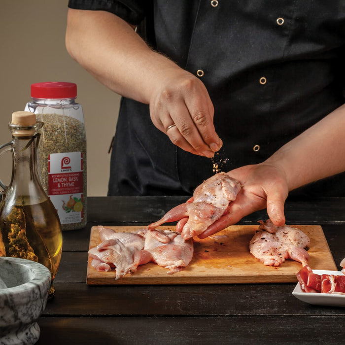 A chef is seasoning Lawrys Lemon Basil &amp; Thyme on quail before cooking.
