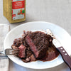 A plate of Lawrys Pepper Supreme seasoned steak with mushrooms and a brown sauce.