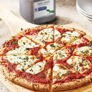 A close-up of a pizza with mozzarella cheese tomato sauce and basil leaves on a wooden cutting board.
