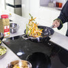 A chef is cooking vegetables in a pan with Lawrys Garlic Rosemary &amp; Lemon Rub seasoning.