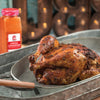 A roasted chicken seasoned with a Chipotle Cinnamon Rub sits in a metal pan.