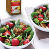 A bowl of salad with spinach strawberries chicken and almonds.