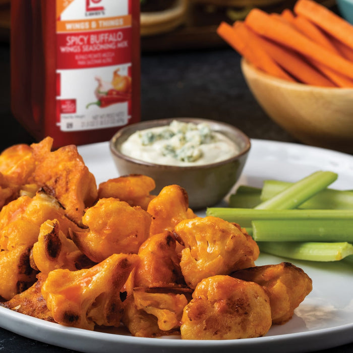 A plate of Lawrys Spicy Buffalo Wings Seasoning Mix cauliflower bites with celery sticks and blue cheese dip.
