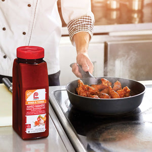 A chef is cooking chicken wings with Lawrys Mango Habanero Wings Seasoning Mix.