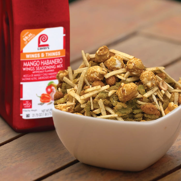 A bowl of Lawrys Mango Habanero Wings Seasoning Mix with a bottle of the seasoning in the background.