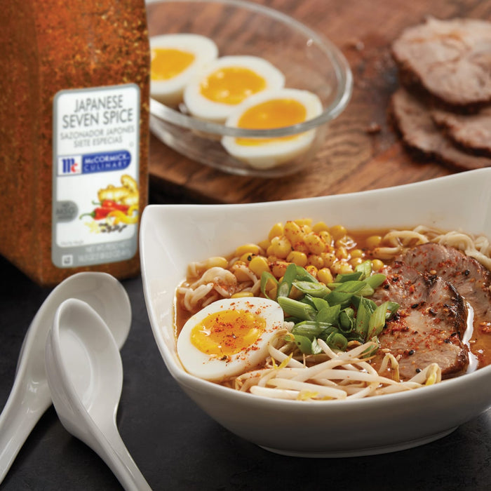 A bowl of ramen with pork corn bean sprouts green onions and a soft-boiled egg topped with McCormick Culinary Japanese Seven Spice.