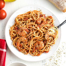 A plate of spaghetti with shrimp and tomato sauce is presented as a delicious and appetizing meal.