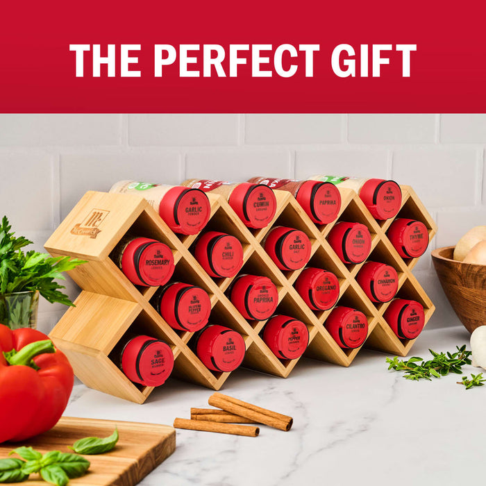 A collection of red-lidded Spiceology spice containers are neatly arranged in a bamboo honeycomb-shaped rack, showcased as the perfect gift.
