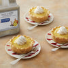 Three lemon tarts with whipped cream on top a fork and a jar of McCormick Culinary Lemon &amp; Pepper Seasoning Salt.
