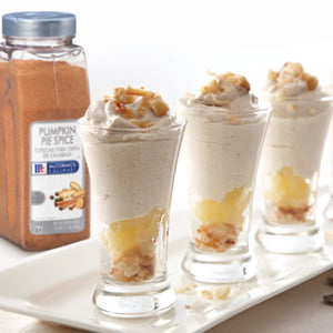 Three glasses of pumpkin pie mousse topped with crushed graham crackers and a jar of McCormick Culinary Pumpkin Pie Spice.