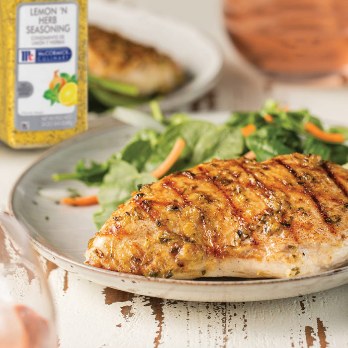A plate of grilled chicken with a side salad seasoned with McCormick Lemon n Herb seasoning.