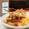 A plate of cheesy polenta topped with white beans mushrooms and tomato sauce.