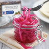 A jar of pickled onions with a fork holding a piece of onion.