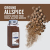 A jar of McCormick Culinary Ground Allspice with whole allspice berries scattered around it.