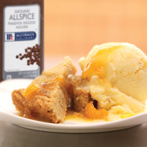 A plate of McCormick Ground Allspice with a scoop of vanilla ice cream and a slice of cake.