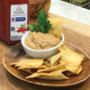 A bowl of hummus with pita chips and a jar of McCormick Culinary Light Chili Powder.