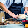 A person is preparing a turkey for cooking using McCormick Culinary Poultry Seasoning.
