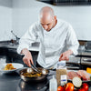 A chef is preparing a meal in a kitchen using McCormick Culinary Rosemary Leaves.