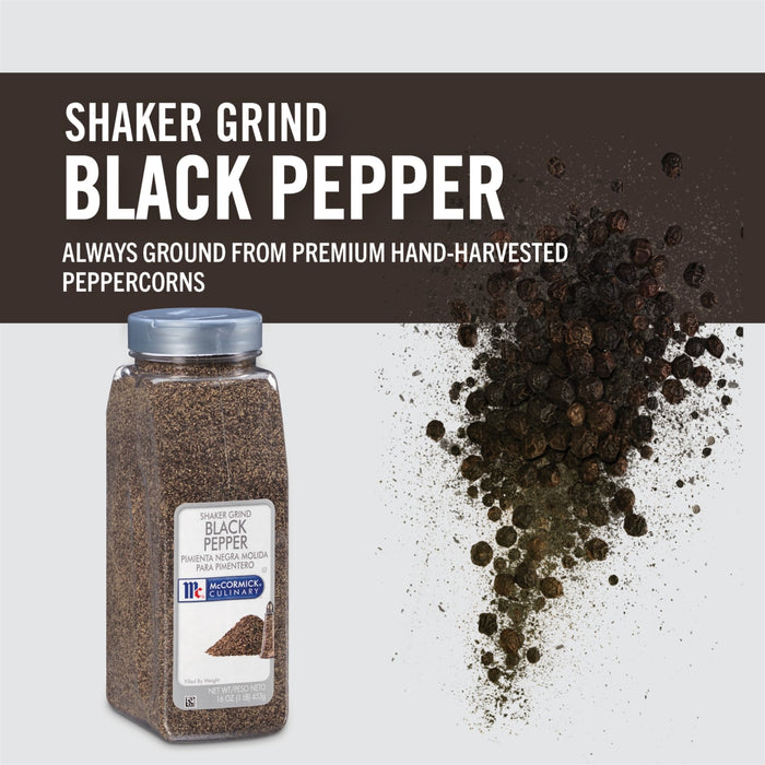 A container of McCormick Culinary Shaker Grind Black Pepper with peppercorns scattered around it.