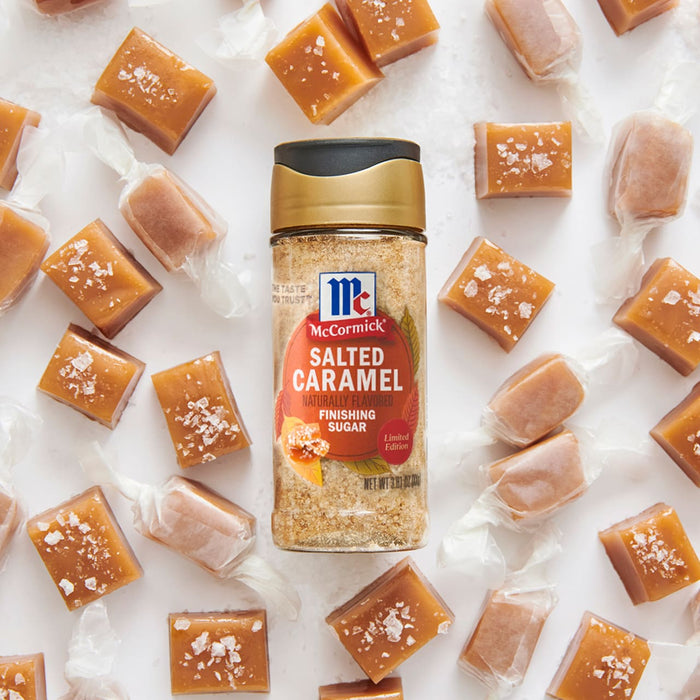 A bottle of McCormick Salted Caramel Pecan seasoning is surrounded by unwrapped and wrapped caramel candies.