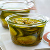 A jar of dill pickle spears with mustard seeds.