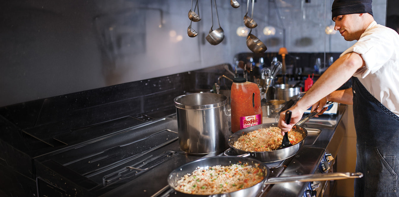 Person cooking in a kitchen with pots and pans on a stove