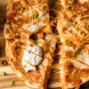 A close-up of a buffalo chicken quesadilla with melted cheese and a side of ranch dressing.