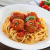 Spaghetti with meatballs and marinara sauce on a white plate.