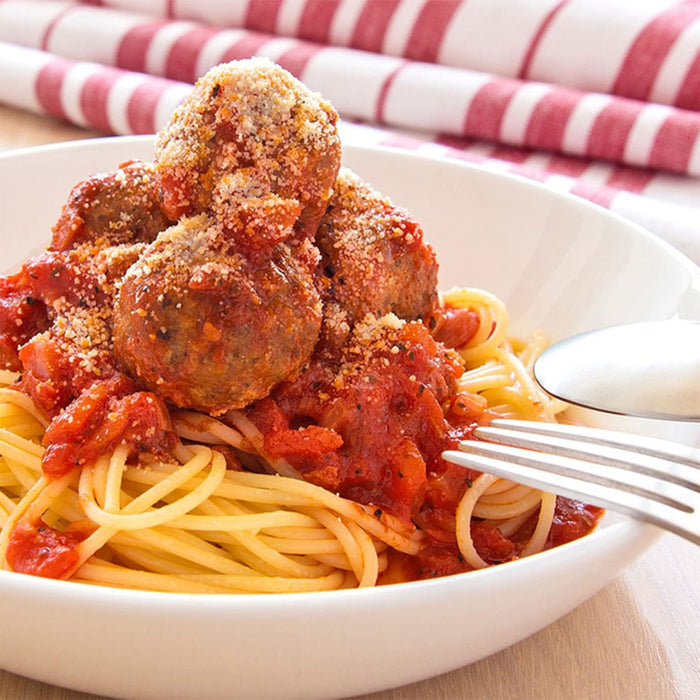 A bowl of spaghetti with meatballs and marinara sauce.