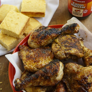 A plate of grilled chicken and cornbread is shown with Zatarains Cajun Injector Creole Garlic marinade.