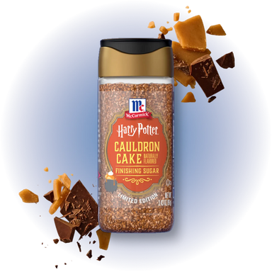 A bottle of McCormick's Harry Potter Cauldron Cake flavor finishing sugar, presented with decorative chocolate and caramel pieces on a white background with a soft blue glow.