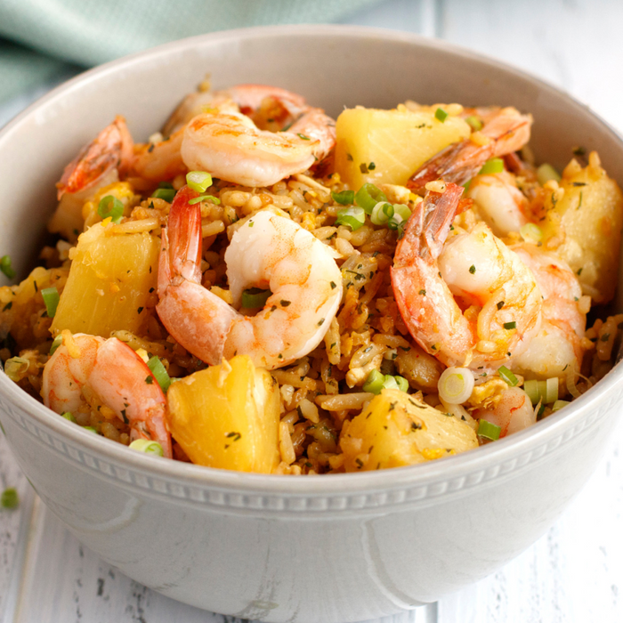 A bowl of pineapple fried rice with shrimp.