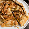 A close-up of a delicious apple tart with a flaky crust and a generous amount of cinnamon.