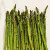 A bunch of asparagus spears are arranged in a row, with the tips facing up.