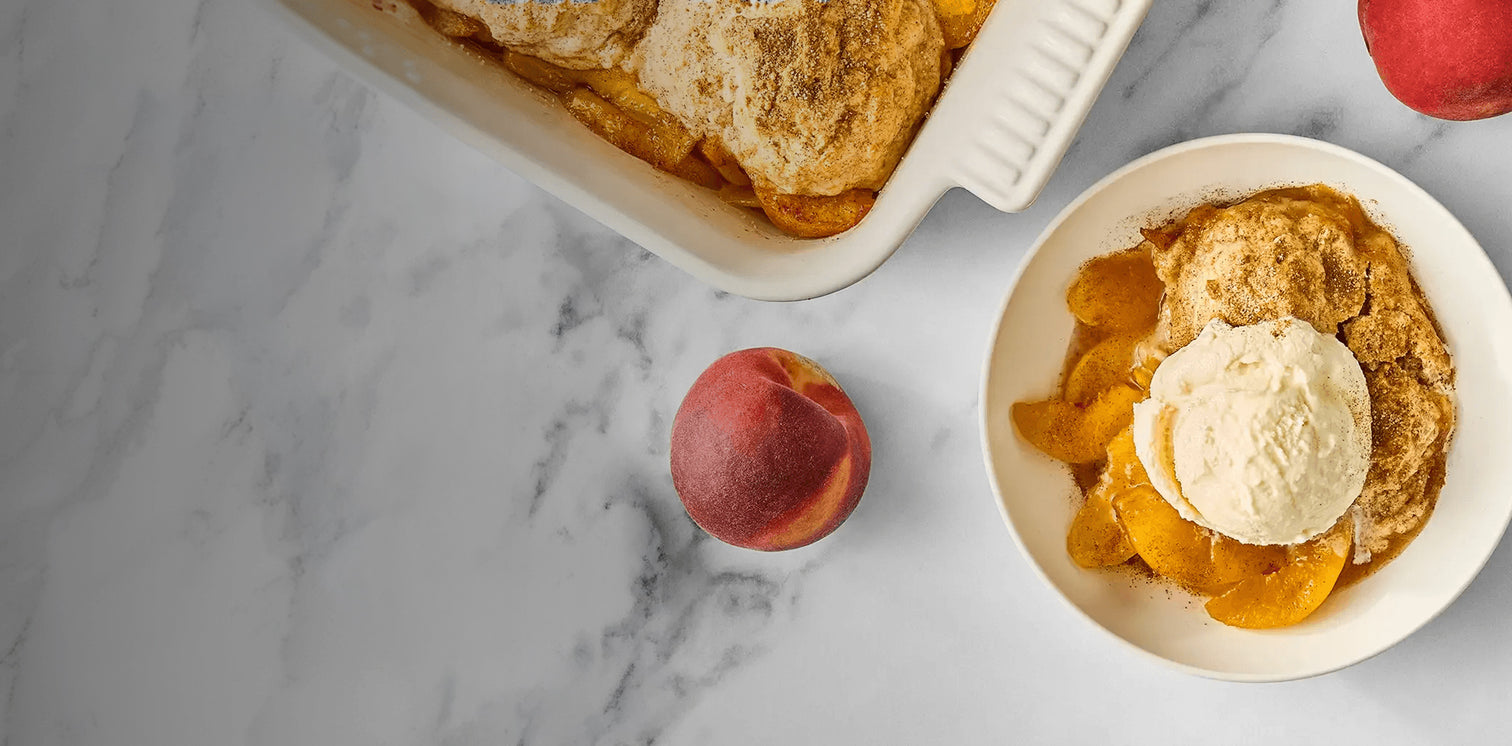 Peach cobbler with ice cream on a marble surface